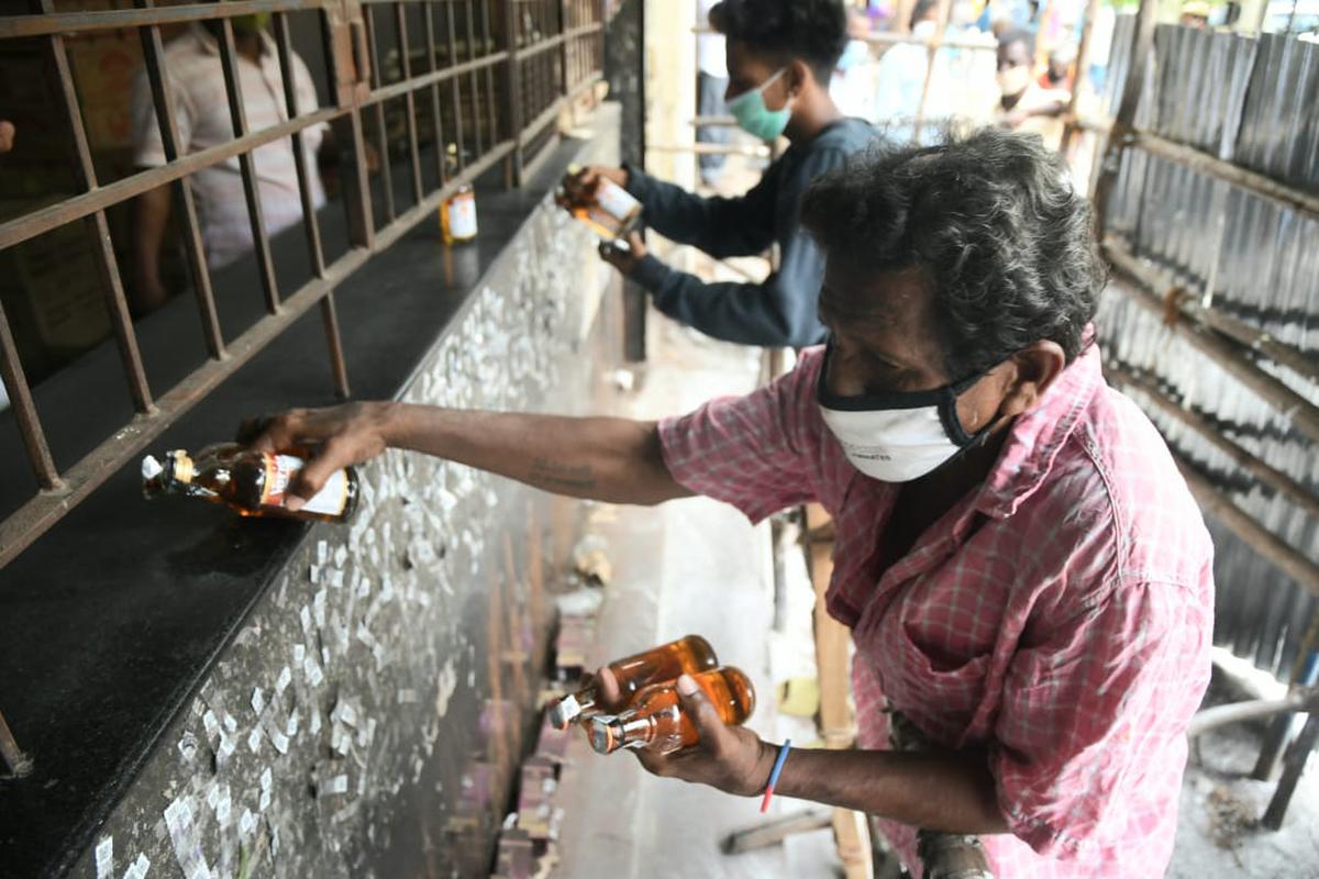 TASMAC liquor shops reopened in parts of the State on June 14, 2021. In the picture, people are seen buying liquor from a TASMAC outlet in Chennai.