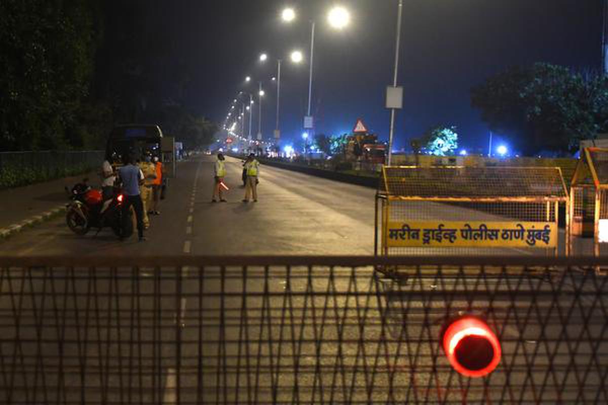 Police keep vigil during the night curfew, imposed in the backdrop of new strain of coronavirus emerging in U.K., at Marine drive in Mumbai on Tuesday night.