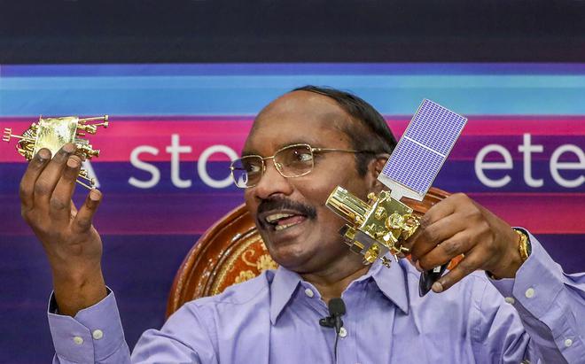ISRO chairman K. Sivan displays a model of Chanrayaan 2 Orbiter and Lander Vikram during a press conference in Bengaluru on August 20, 2019.