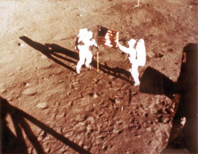 (FILES) In this NASA handout file photo taken on July 20, 1969 US astronauts Neil Armstrong and Buzz Aldrin deploy the US flag on the lunar surface during the Apollo 11 lunar landing mission.