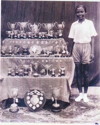 13-year-old Ila posing with her many trophies for a newspaper feature in 1938