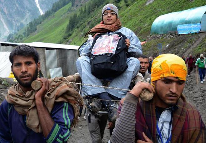SYNCRETIC TRADITION: A pilgrim being carried to the Amarnath cave by local porters