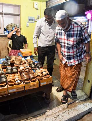 A customer tries on the traditional arba chappal at a footwear store