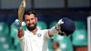 Indian cricketer Cheteshwar Pujara raises his bat and helmet in celebration after scoring a century (100 runs) during the first day of the second Test match between Sri Lanka and India at the Sinhalease Sports Club (SSC) Ground in Colombo.